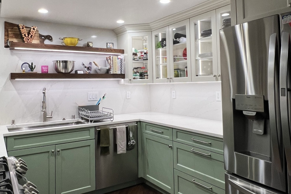 Photo of a mid-sized transitional u-shaped separate kitchen in Orange County with an undermount sink, recessed-panel cabinets, green cabinets, quartz benchtops, white splashback, engineered quartz splashback, stainless steel appliances, vinyl floors, no island, multi-coloured floor and white benchtop.