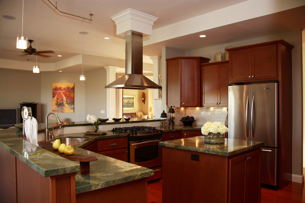 Inspiration for a mid-sized transitional u-shaped dark wood floor and brown floor open concept kitchen remodel in Seattle with an undermount sink, shaker cabinets, dark wood cabinets, marble countertops, white backsplash, porcelain backsplash, stainless steel appliances and two islands