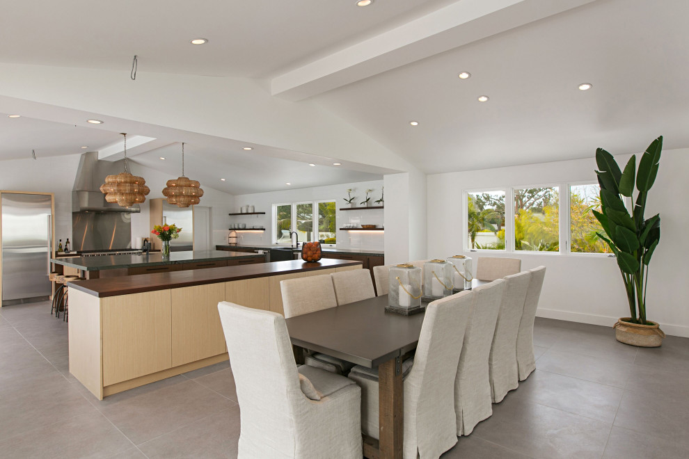Photo of a large beach style kitchen/dining combo in San Diego with white walls, concrete floors, no fireplace and beige floor.