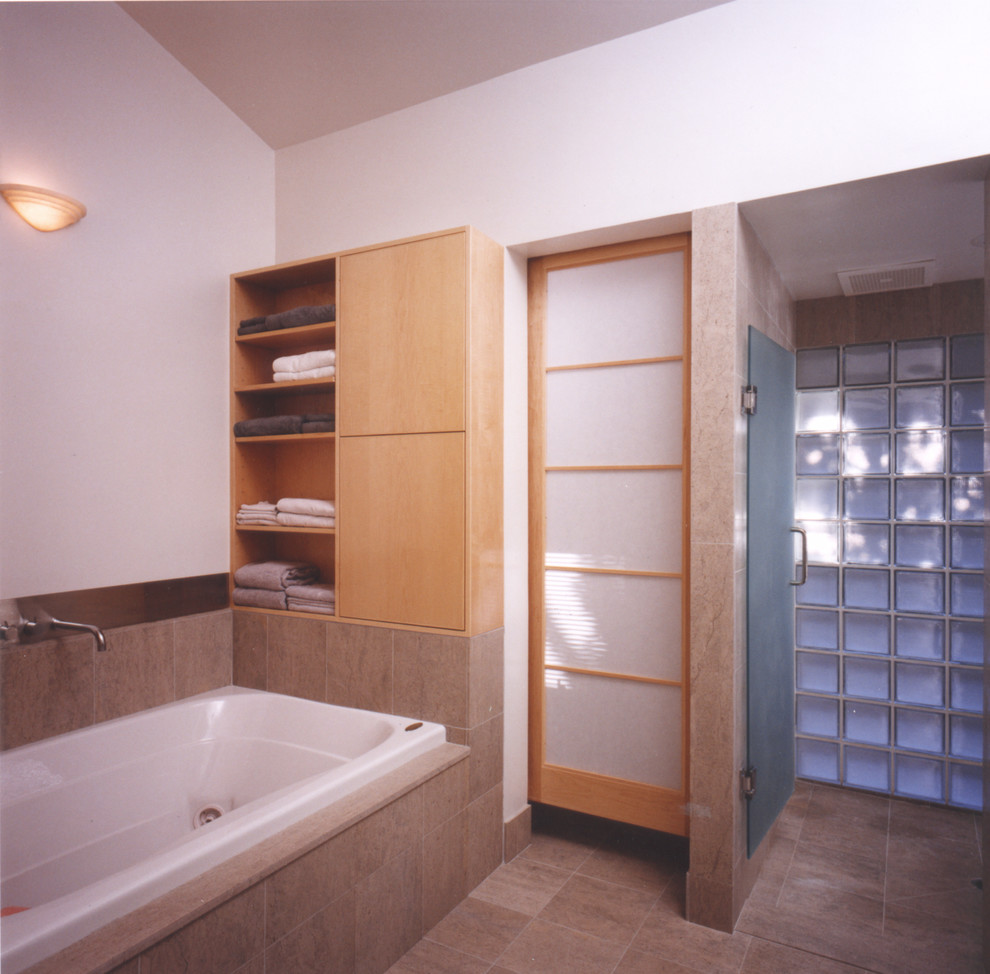 Inspiration for a mid-sized asian master bathroom in San Francisco with flat-panel cabinets, light wood cabinets, a drop-in tub, an alcove shower, a one-piece toilet, multi-coloured tile, limestone, white walls, limestone floors, a drop-in sink, limestone benchtops, grey floor and a hinged shower door.