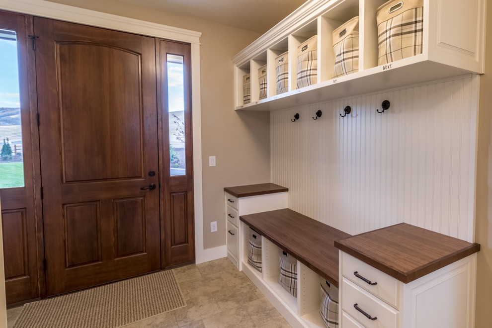 This is an example of a mid-sized country mudroom in Salt Lake City with beige walls, porcelain floors, a dutch front door and a medium wood front door.