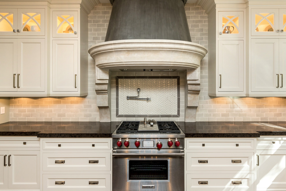 Eat-in kitchen - large transitional u-shaped dark wood floor eat-in kitchen idea with a farmhouse sink, shaker cabinets, white cabinets, marble countertops, gray backsplash, subway tile backsplash, stainless steel appliances and two islands