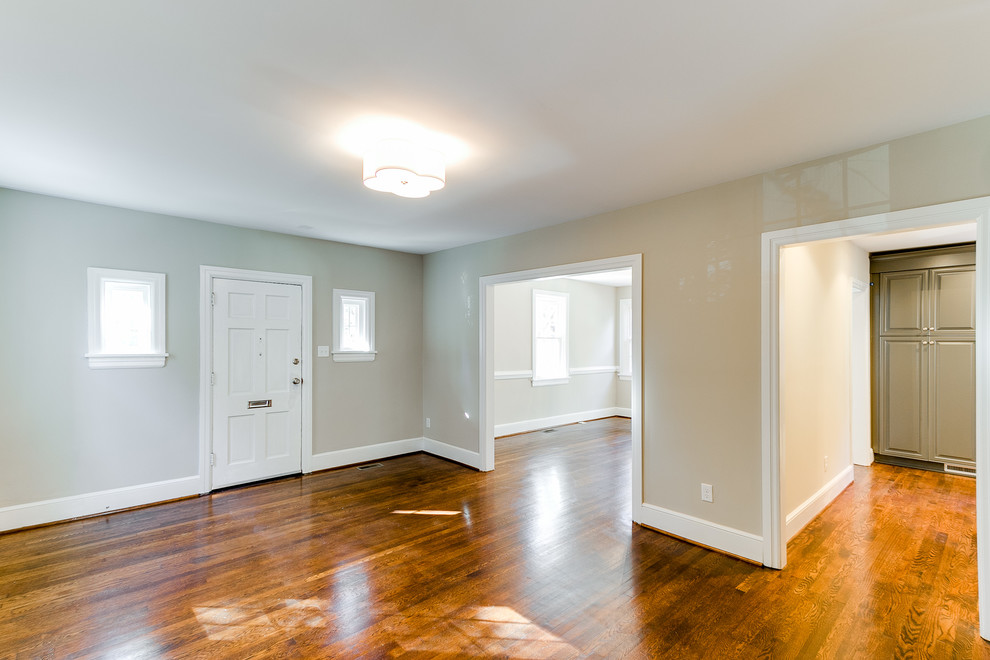 Example of a medium tone wood floor front door design in Richmond with beige walls and a white front door