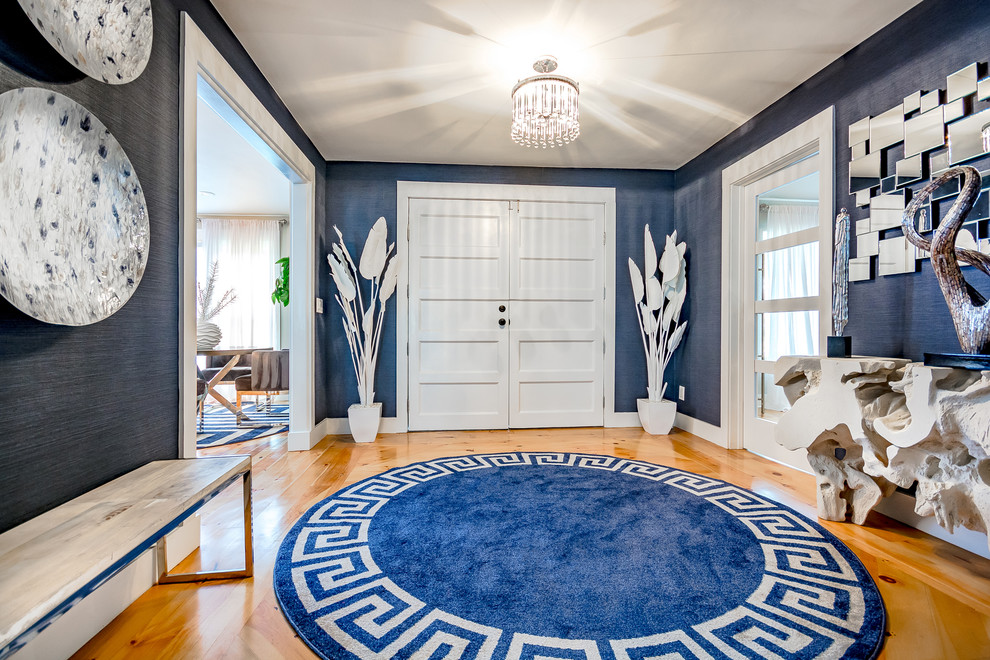 This is an example of a large contemporary foyer in Jacksonville with blue walls, light hardwood floors, a double front door, a white front door and brown floor.