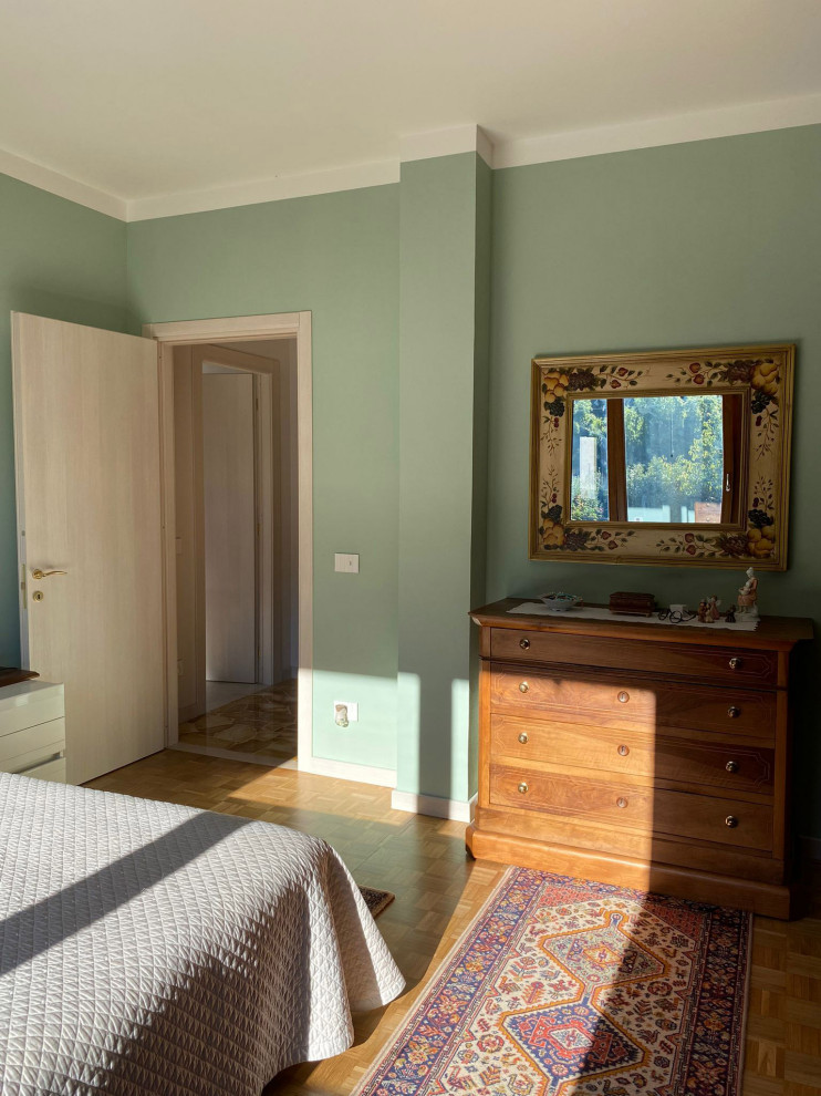 Idee per una camera matrimoniale classica di medie dimensioni con pareti verdi, parquet chiaro, pavimento marrone, carta da parati e abbinamento di mobili antichi e moderni