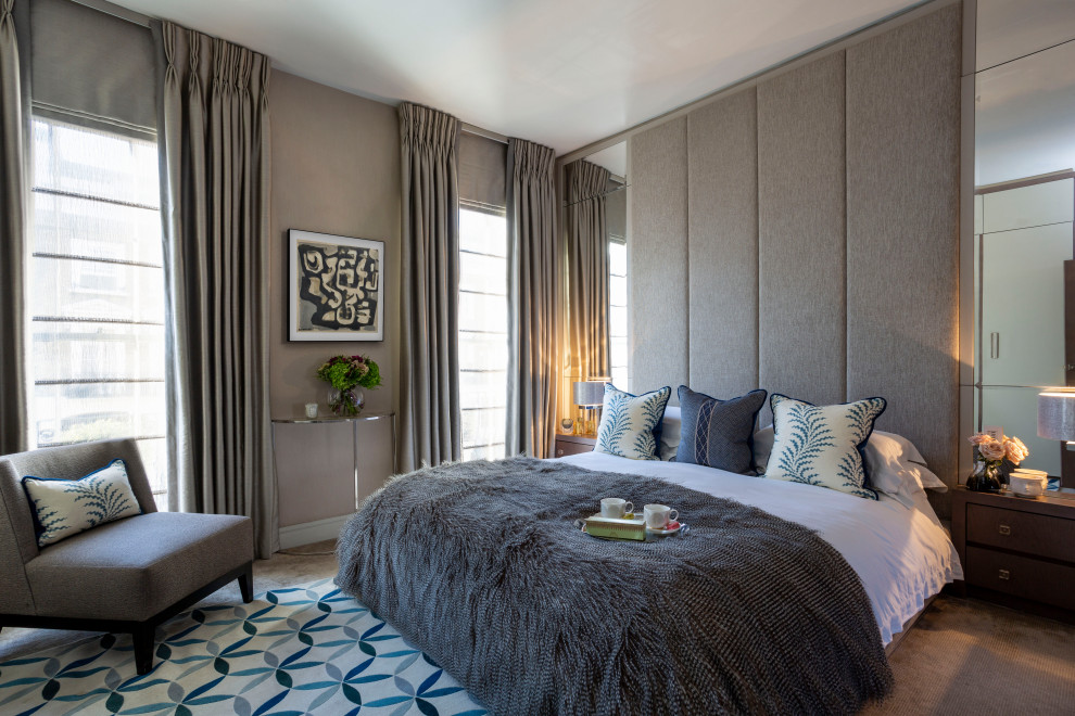 Inspiration for a large contemporary master and grey and brown bedroom in London with beige walls, carpet, beige floors and wallpapered walls.