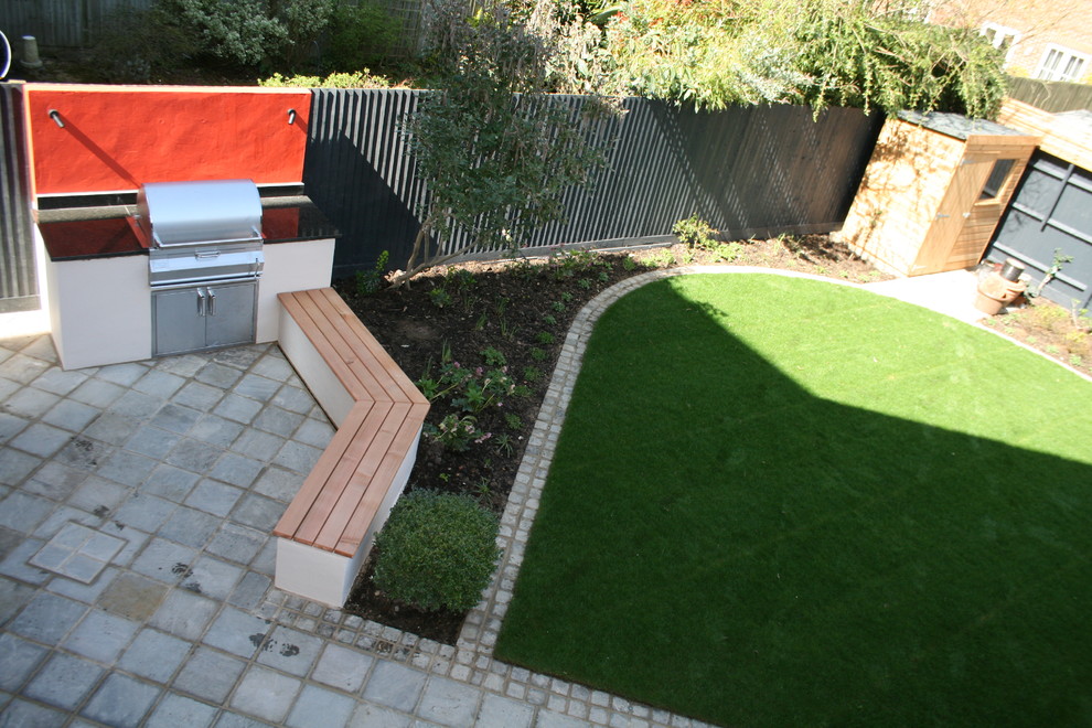 Photo of a small contemporary backyard partial sun garden for spring in Oxfordshire with a fire feature and natural stone pavers.