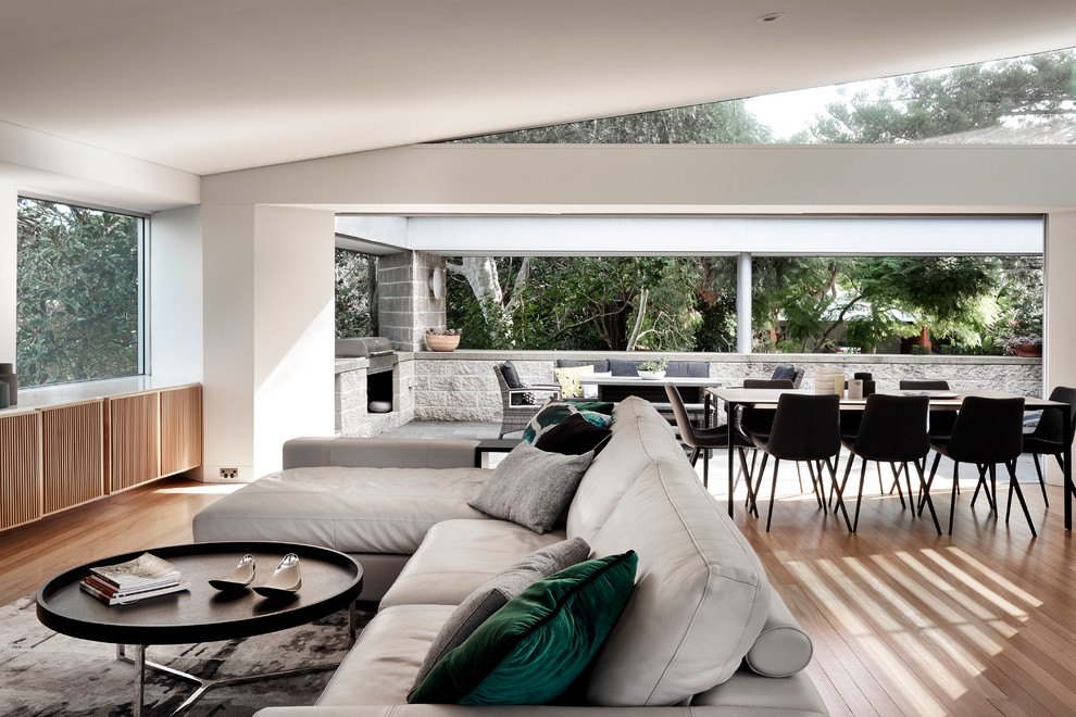 Design ideas for a large contemporary open concept living room in Sydney with light hardwood floors.