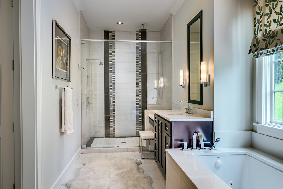 Large contemporary master bathroom in Nashville with recessed-panel cabinets, dark wood cabinets, a drop-in tub, black and white tile, white walls, travertine floors and an undermount sink.