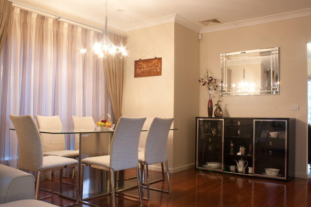 This is an example of a mid-sized contemporary dining room in Sydney with beige walls and medium hardwood floors.