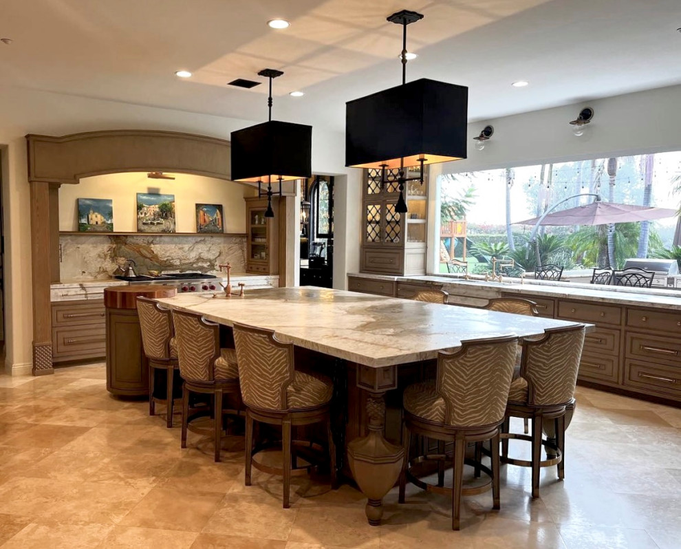 Expansive mediterranean u-shaped eat-in kitchen in San Diego with raised-panel cabinets, beige cabinets, with island, a farmhouse sink, marble benchtops, green splashback, marble splashback, stainless steel appliances, travertine floors, beige floor and green benchtop.