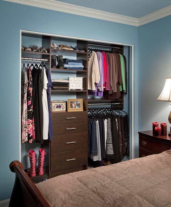 Small traditional gender-neutral built-in wardrobe in Orange County with open cabinets and dark wood cabinets.