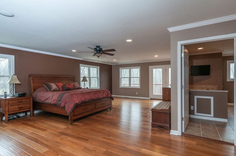 Large elegant master medium tone wood floor and brown floor bedroom photo in Chicago with brown walls