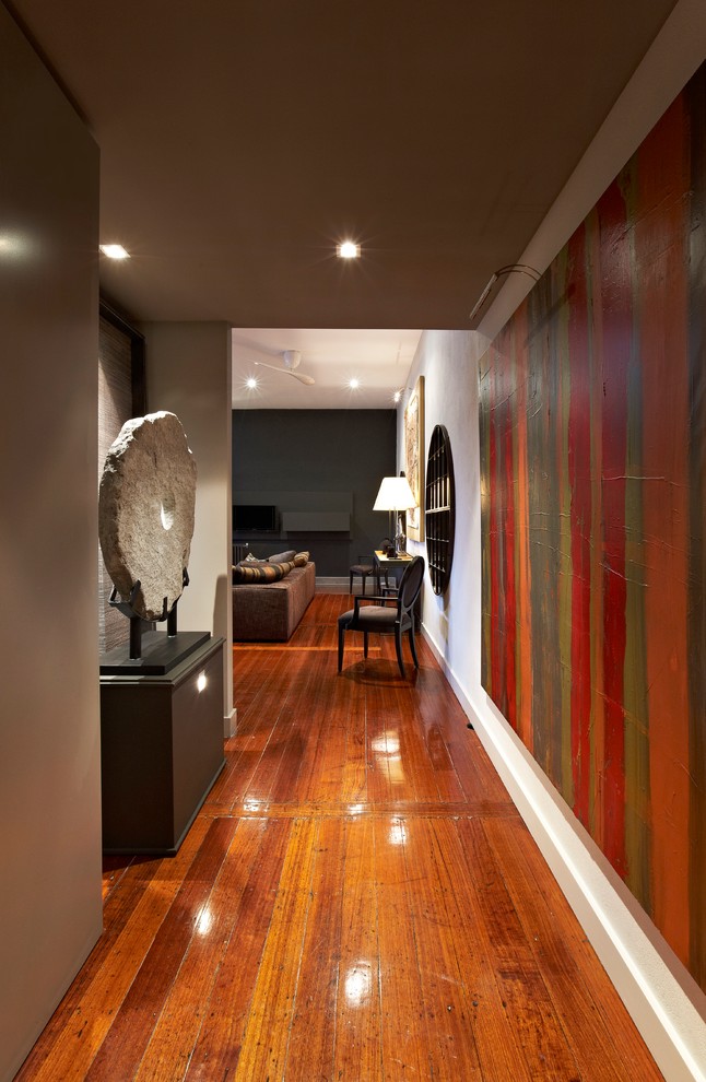 Design ideas for a small contemporary entry hall in Melbourne with grey walls and light hardwood floors.
