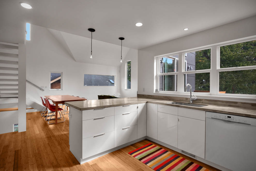 Inspiration for a modern eat-in kitchen in Seattle with white appliances, a single-bowl sink, flat-panel cabinets and white cabinets.