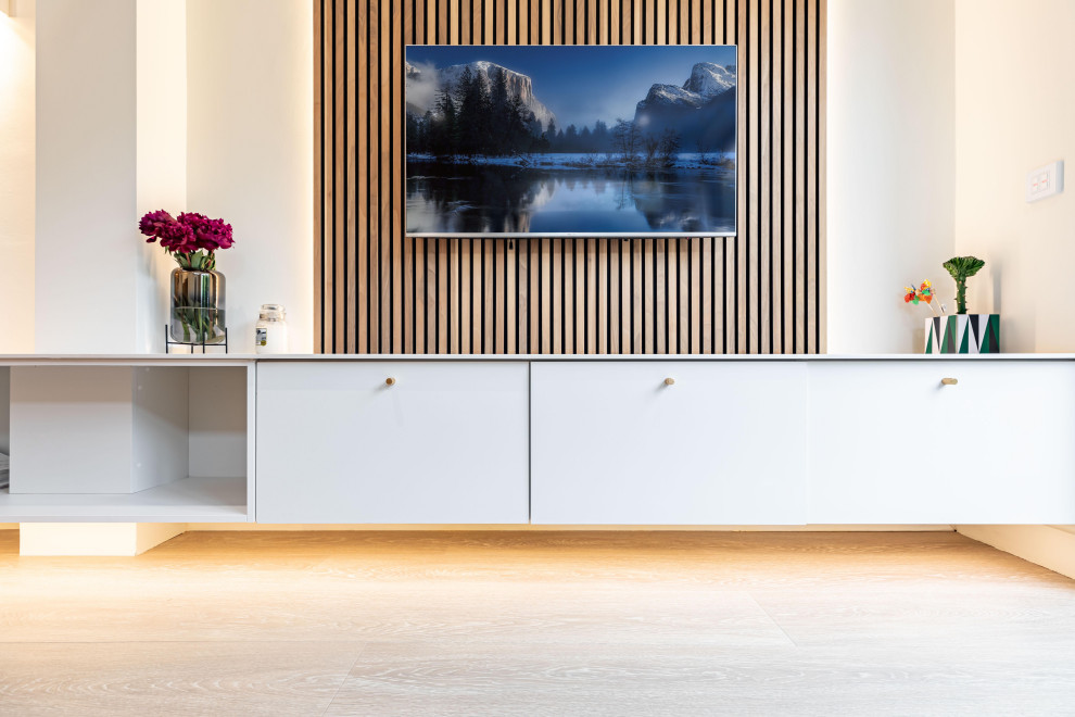 Diseño de salón abierto minimalista pequeño sin chimenea con paredes beige, suelo de madera en tonos medios, televisor colgado en la pared, suelo marrón y panelado