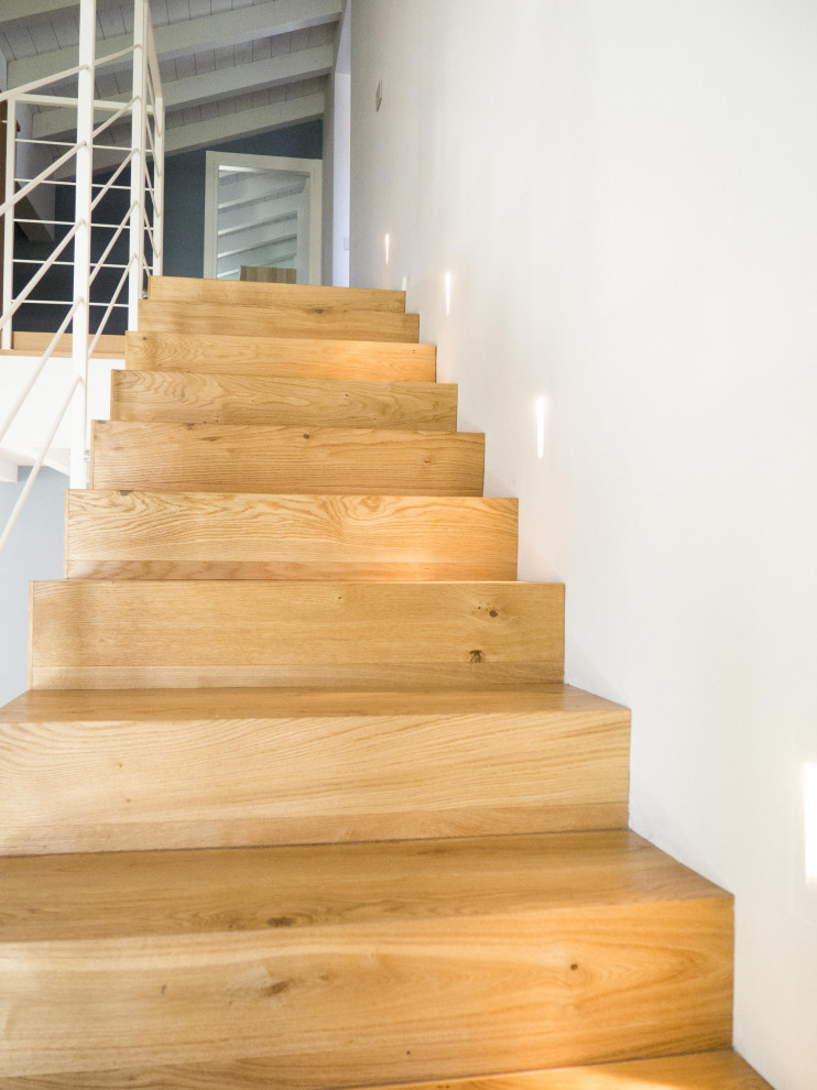 Inspiration for a large scandinavian wood straight staircase in Other with wood risers and metal railing.