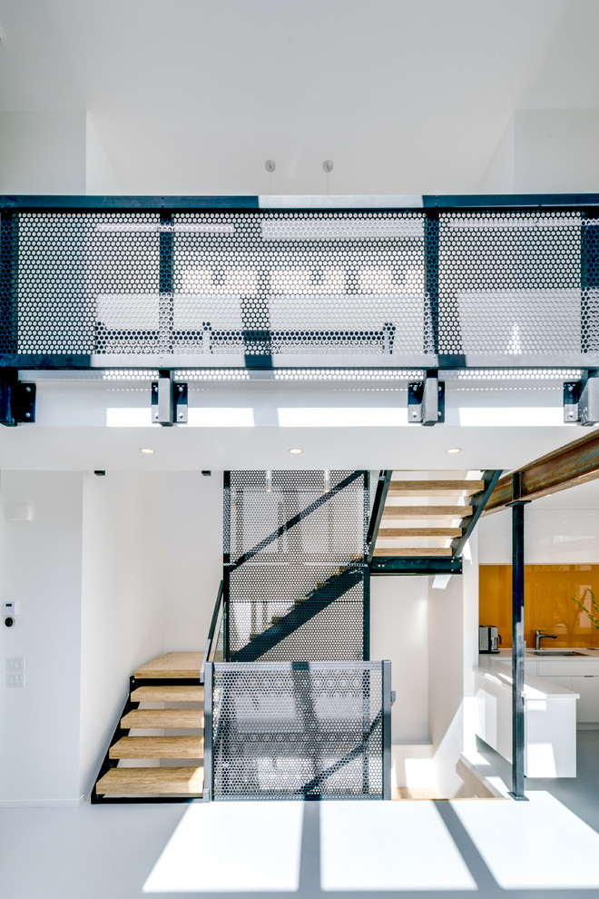 This is an example of an industrial wood u-shaped staircase in Calgary with open risers and metal railing.