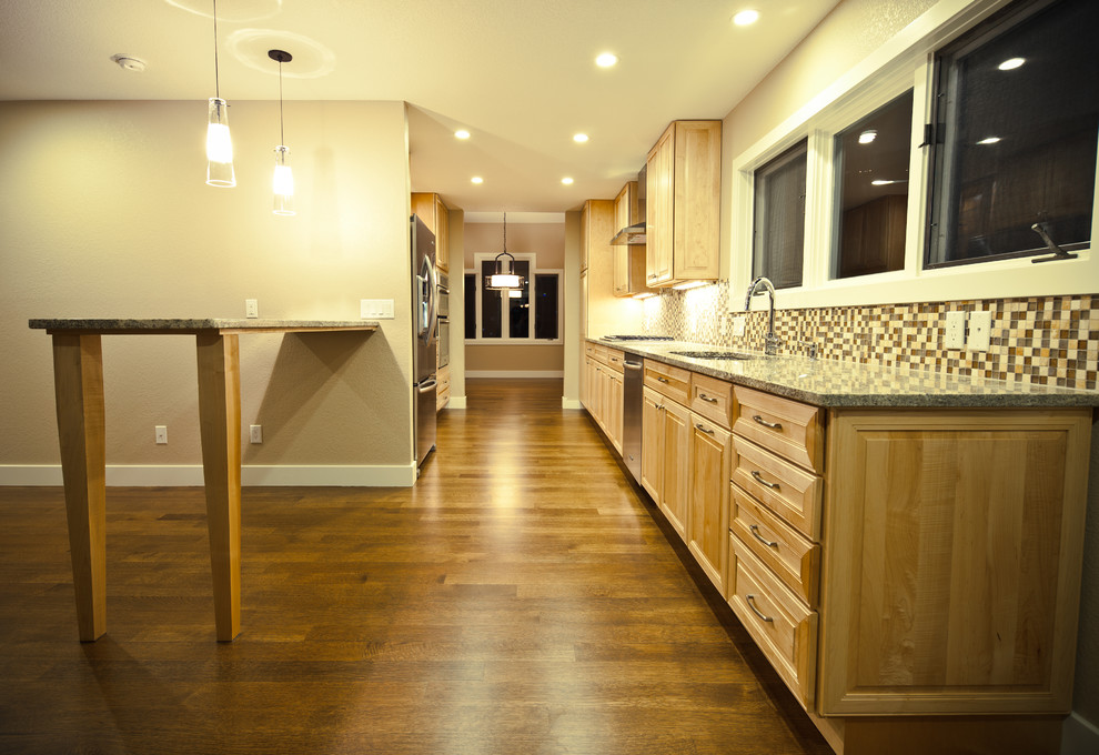 Enclosed kitchen - mid-sized transitional galley medium tone wood floor and brown floor enclosed kitchen idea in Denver with a double-bowl sink, raised-panel cabinets, medium tone wood cabinets, granite countertops, multicolored backsplash, mosaic tile backsplash, stainless steel appliances and no island