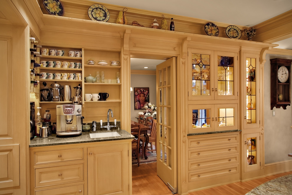 Photo of a traditional separate kitchen in Seattle with glass-front cabinets and beige cabinets.