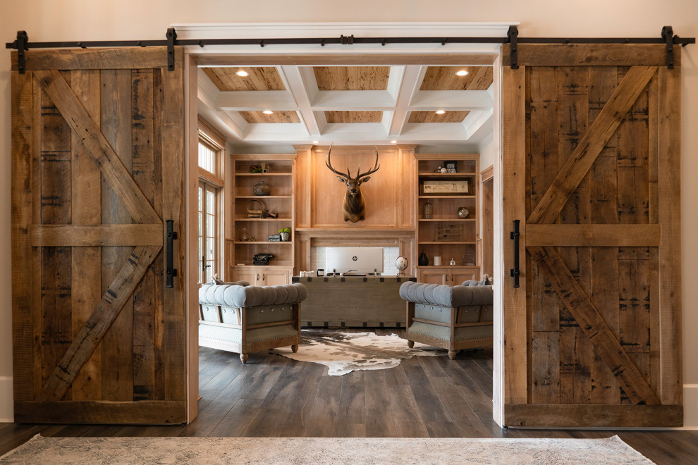 Mid-sized country home office in Atlanta with a library, beige walls, dark hardwood floors, a standard fireplace, a wood fireplace surround, a freestanding desk, brown floor, coffered and panelled walls.