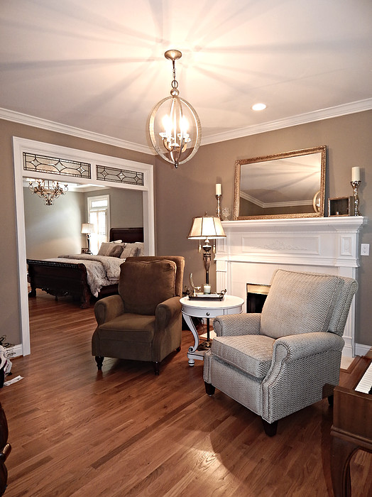 Inspiration for a mid-sized transitional formal enclosed living room in Birmingham with brown walls, dark hardwood floors, a standard fireplace, a plaster fireplace surround, no tv and brown floor.