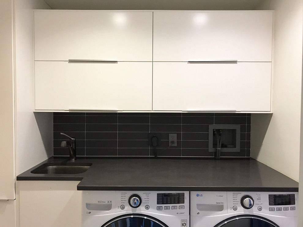 Inspiration for a small modern single-wall utility room in New York with an undermount sink, flat-panel cabinets, white cabinets, quartz benchtops, grey walls, porcelain floors and a side-by-side washer and dryer.