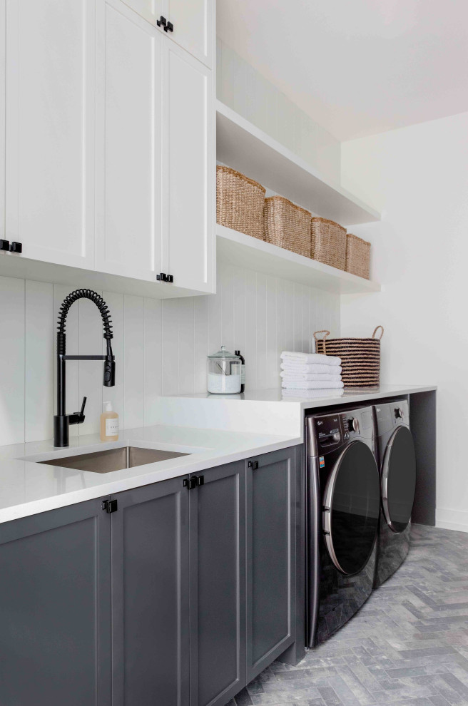Inspiration for a transitional laundry room in Austin with shaker cabinets, grey cabinets, white walls and grey floor.