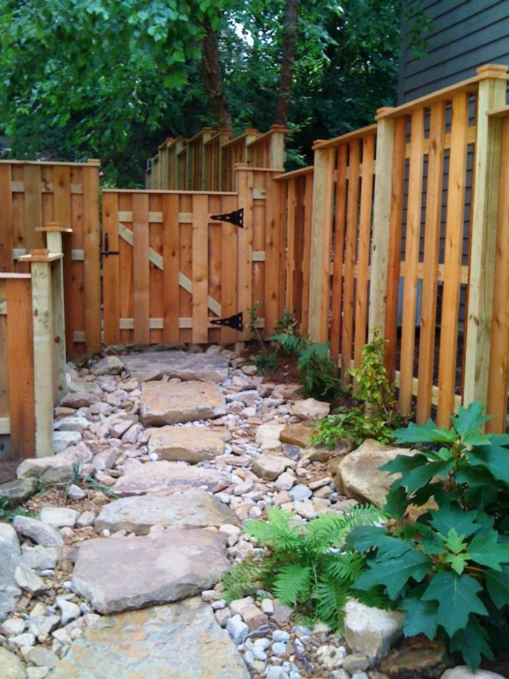 This is an example of a mid-sized transitional full sun backyard stone landscaping in Cincinnati for spring.
