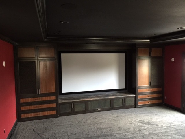 Inspiration for a large contemporary enclosed home theatre in San Francisco with red walls, carpet, a projector screen and grey floor.