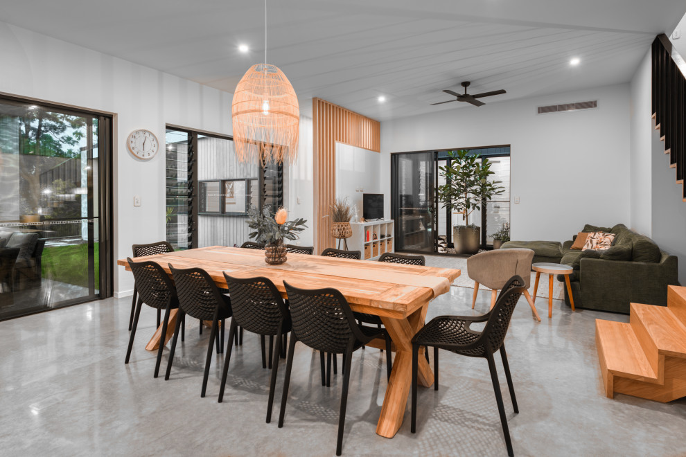 Photo of a contemporary open plan dining in Sunshine Coast with white walls, concrete floors and grey floor.