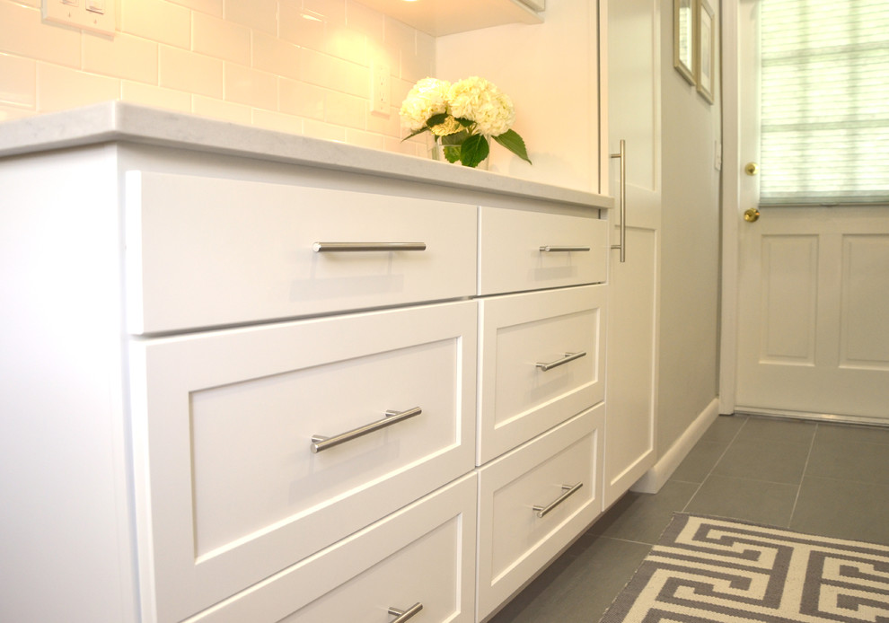 Inspiration for a small transitional galley porcelain tile enclosed kitchen remodel in Miami with an undermount sink, flat-panel cabinets, white cabinets, quartz countertops, white backsplash, subway tile backsplash and stainless steel appliances