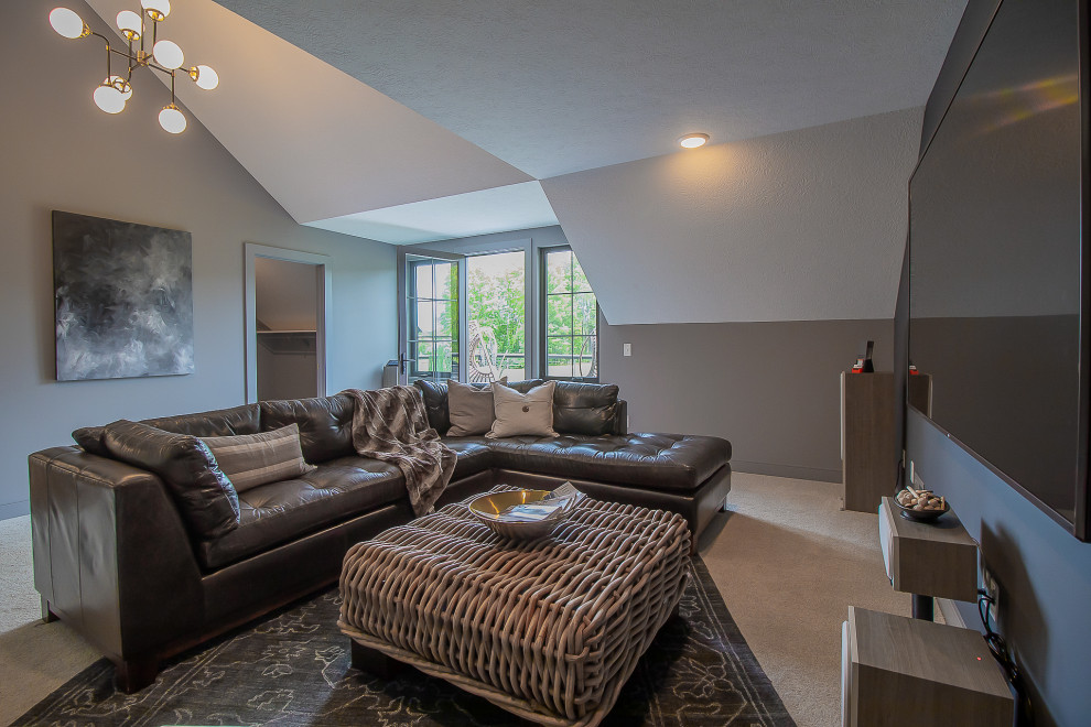 This is an example of an expansive transitional open concept home theatre in Cleveland with grey walls, carpet, a wall-mounted tv and grey floor.