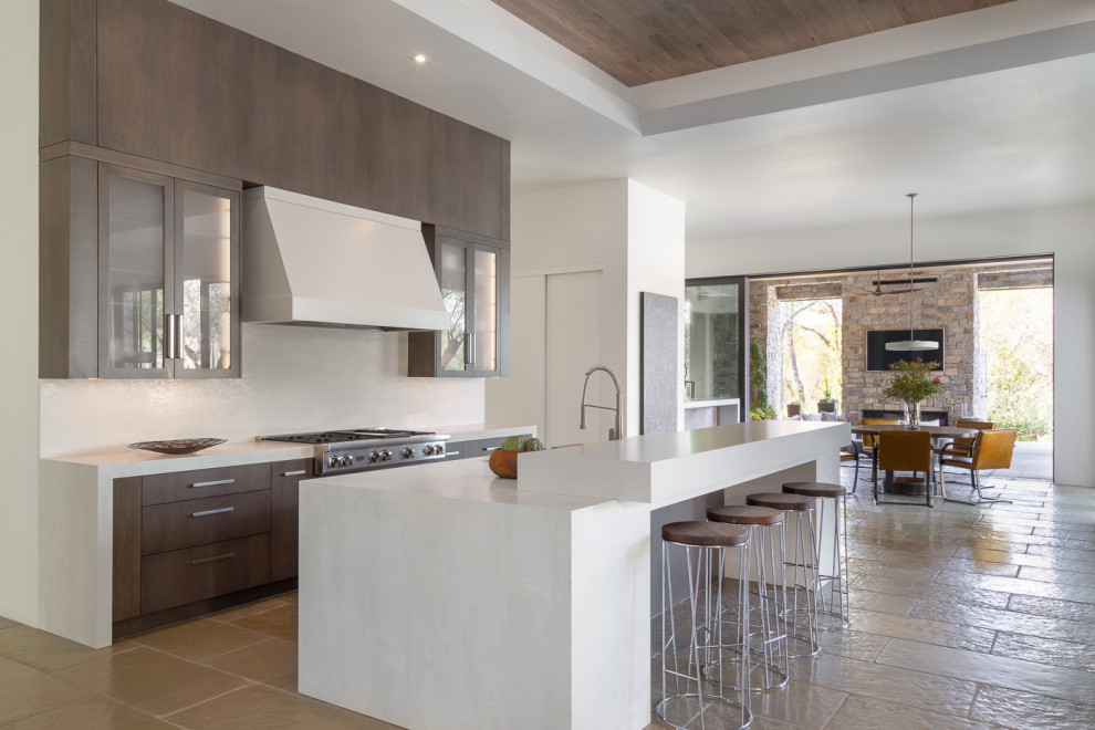Contemporary kitchen in Sacramento with glass-front cabinets, dark wood cabinets, white splashback, stainless steel appliances, with island, beige floor and white benchtop.