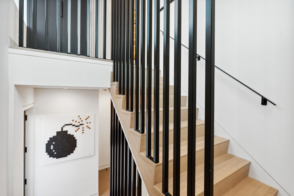 Foto de escalera en U minimalista grande con escalones de madera, contrahuellas de metal y barandilla de metal