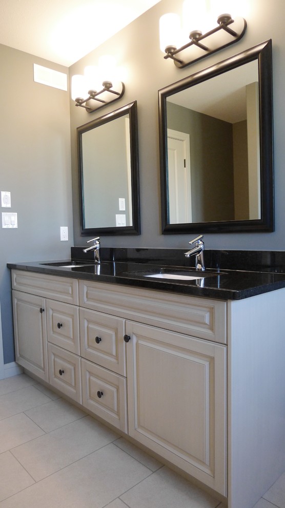 Example of a small transitional master drop-in bathtub design with raised-panel cabinets, white cabinets, granite countertops and a hinged shower door