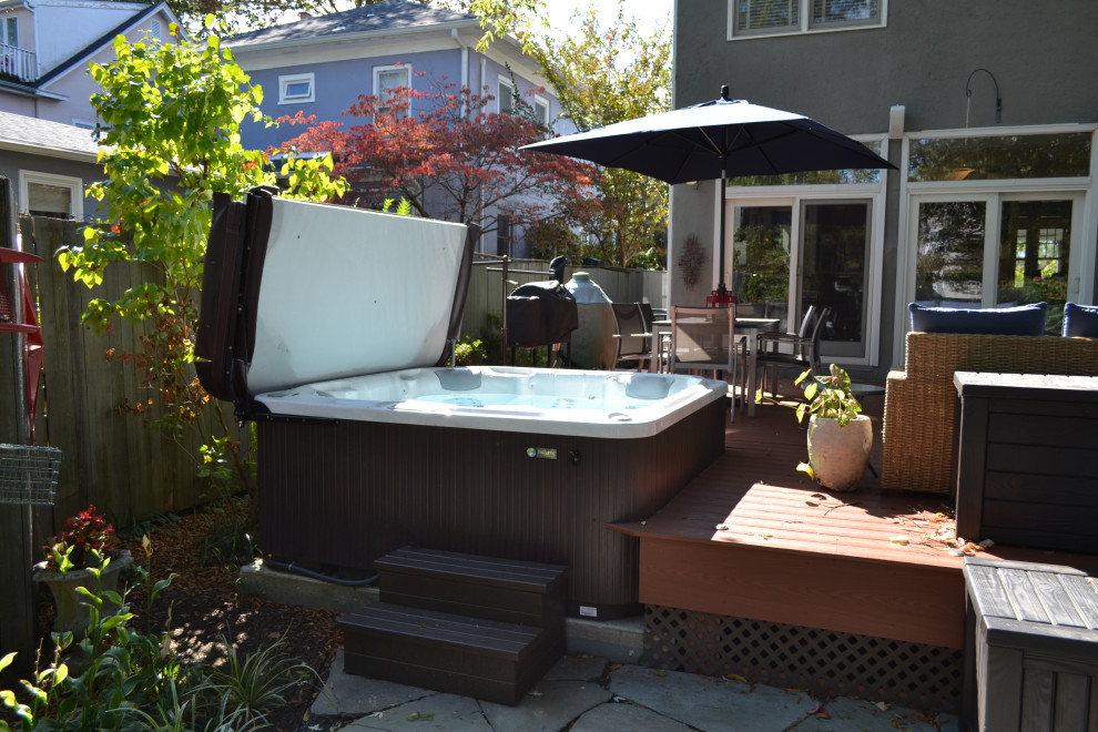 Example of a mid-sized transitional backyard stone deck design in Baltimore with a fire pit and no cover