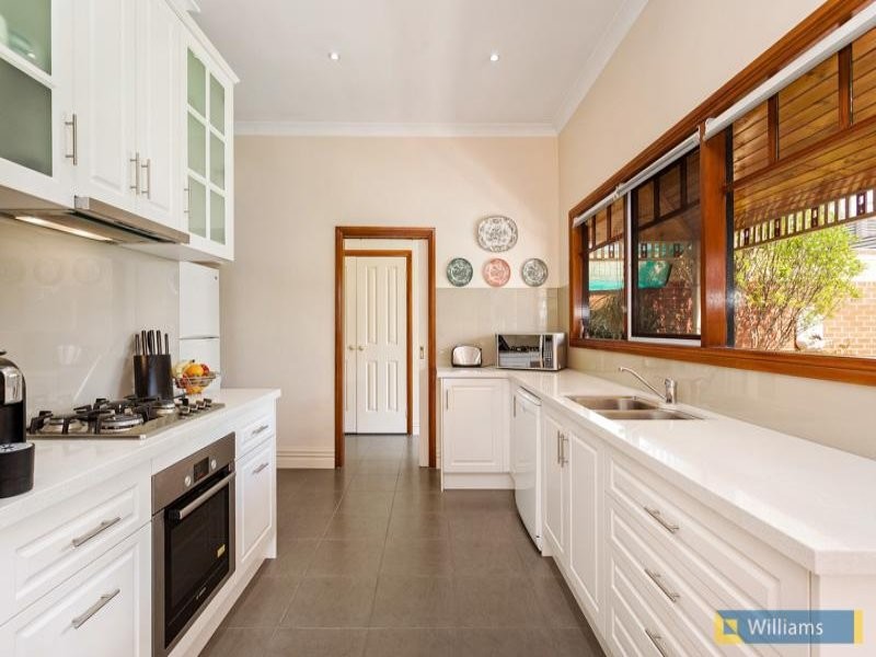 Transitional galley kitchen pantry in Melbourne with an undermount sink, recessed-panel cabinets, beige cabinets, quartz benchtops, beige splashback, glass sheet splashback, stainless steel appliances, ceramic floors and no island.