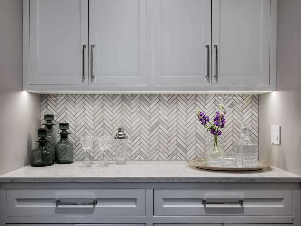 Inspiration for a small transitional single-wall wet bar in Chicago with no sink, recessed-panel cabinets, white cabinets, marble benchtops, white splashback and marble splashback.