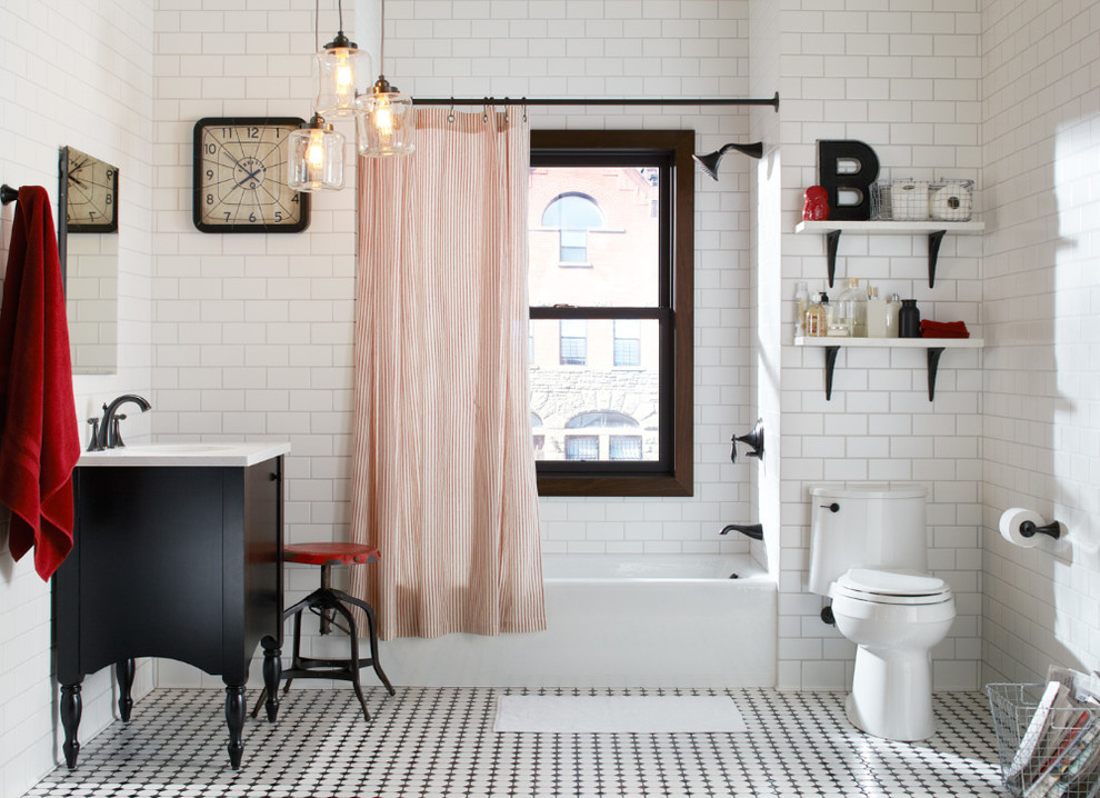 Inspiration for a mid-sized traditional kids bathroom in Milwaukee with dark wood cabinets, solid surface benchtops, an alcove tub, a one-piece toilet, mosaic tile, white walls, a console sink, black and white tile, flat-panel cabinets and a freestanding vanity.