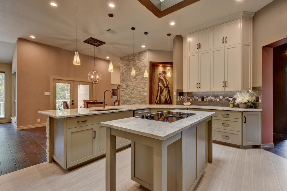 Photo of a mid-sized u-shaped separate kitchen in Austin with a double-bowl sink, shaker cabinets, beige cabinets, granite benchtops, multi-coloured splashback, stainless steel appliances, porcelain floors, multiple islands, grey floor and beige benchtop.