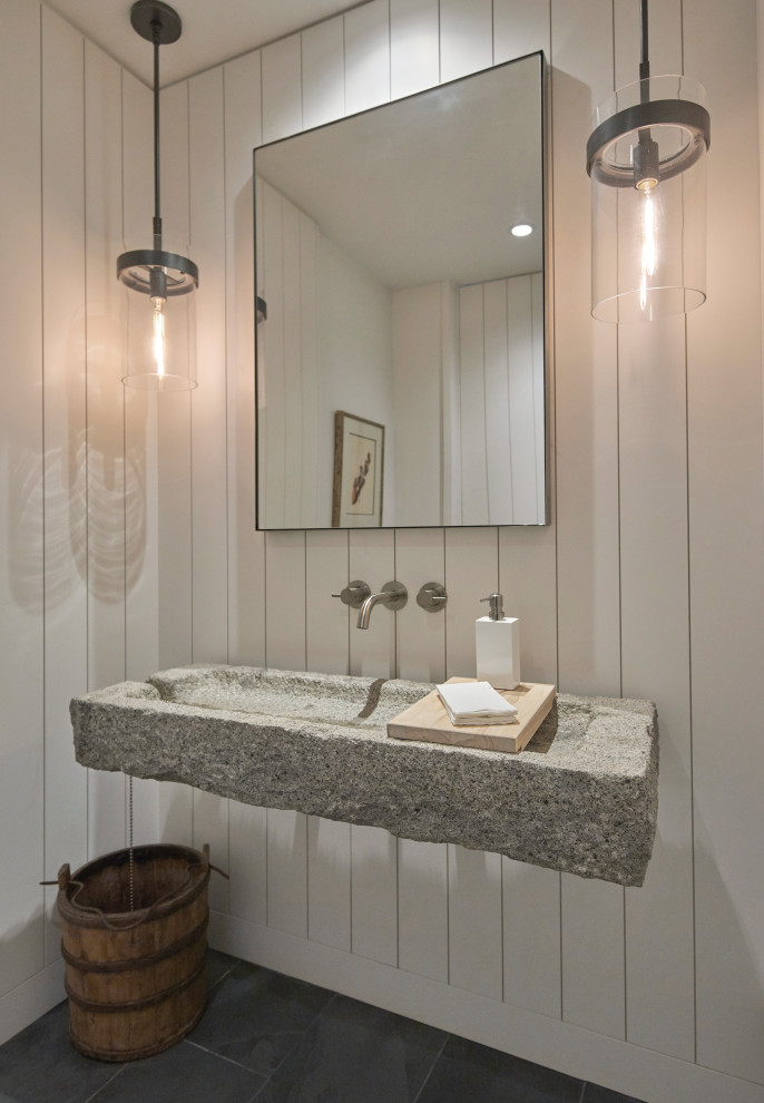 Photo of a mid-sized country powder room in Chicago with white walls, slate floors, a trough sink, granite benchtops, grey floor, grey benchtops, a floating vanity and planked wall panelling.