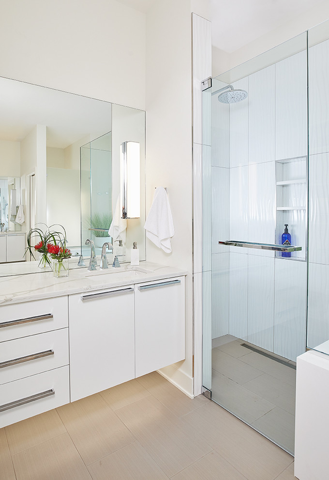 Photo of a large contemporary master bathroom in Grand Rapids with flat-panel cabinets, white cabinets, a curbless shower, white tile, ceramic tile, white walls, ceramic floors, an undermount sink, engineered quartz benchtops, beige floor, a hinged shower door and white benchtops.