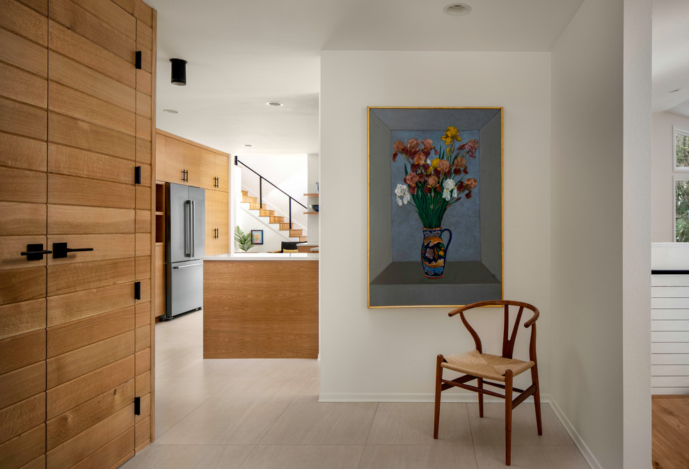 This is an example of a midcentury foyer in Portland with white walls, travertine floors, a single front door and white floor.