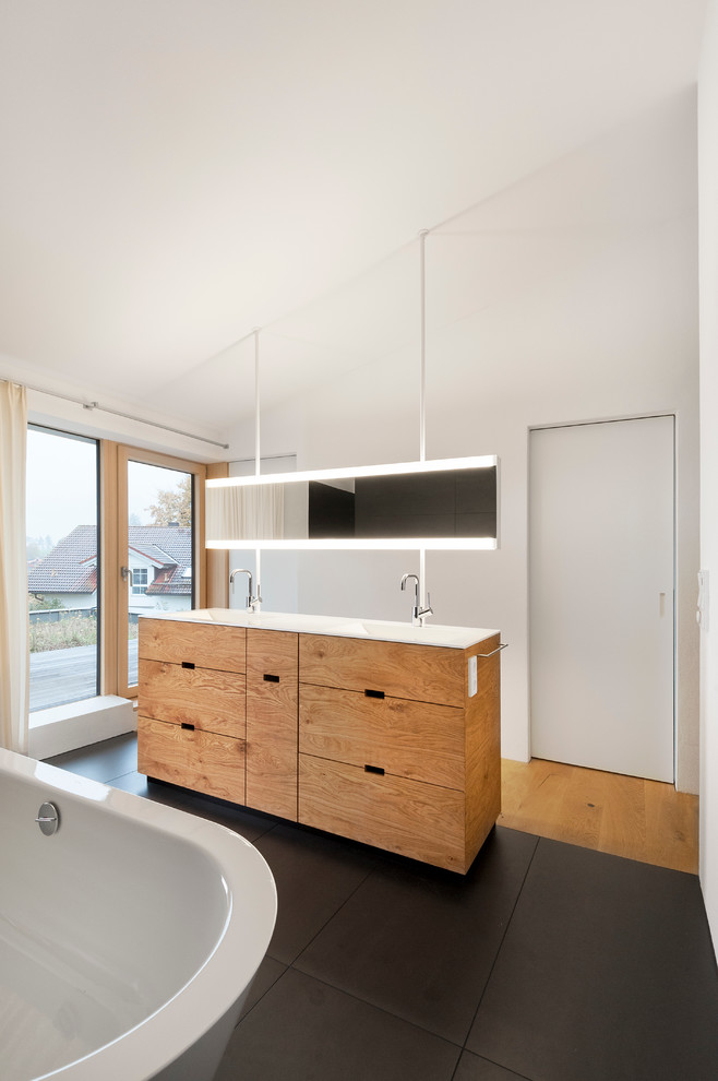 Large contemporary bathroom in Other with flat-panel cabinets, medium wood cabinets, a freestanding tub, white walls and an integrated sink.