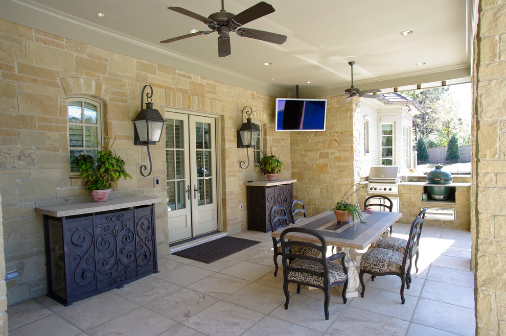 Inspiration for a mid-sized traditional backyard patio in Other with an outdoor kitchen, tile and a roof extension.