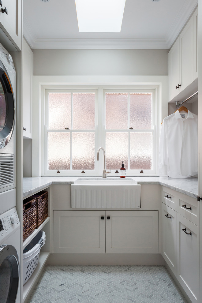Design ideas for a mid-sized transitional u-shaped dedicated laundry room in Sydney with a farmhouse sink, recessed-panel cabinets, grey cabinets, blue walls, marble floors and grey floor.