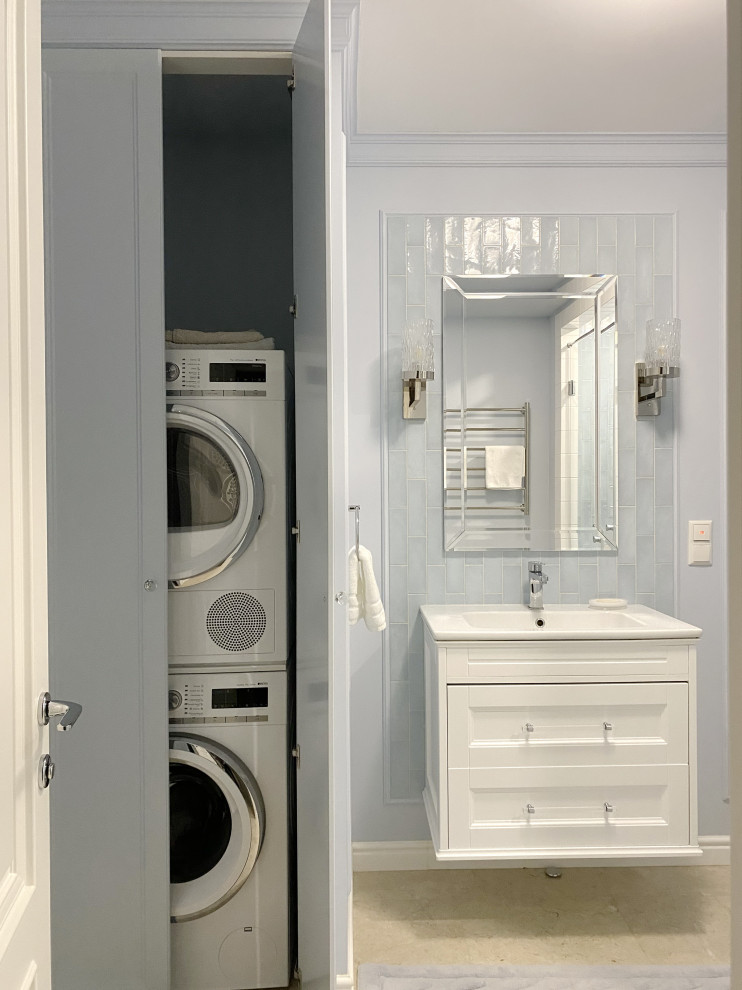 Bild på ett mellanstort badrum med dusch, med luckor med infälld panel, blå skåp, en dusch i en alkov, en vägghängd toalettstol, blå kakel, keramikplattor, blå väggar, marmorgolv, ett väggmonterat handfat, beiget golv och dusch med gångjärnsdörr