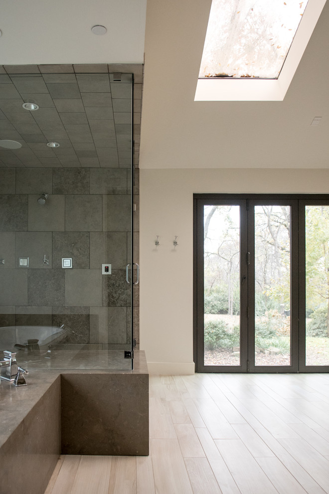Mid-sized transitional master gray tile and cement tile light wood floor and beige floor drop-in bathtub photo in Dallas with flat-panel cabinets, gray cabinets, gray walls, a drop-in sink, concrete countertops and a hinged shower door