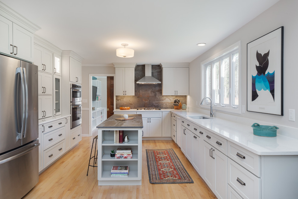 Large transitional u-shaped medium tone wood floor and brown floor enclosed kitchen photo in Boston with a single-bowl sink, shaker cabinets, gray cabinets, quartz countertops, gray backsplash, stainless steel appliances, an island and white countertops
